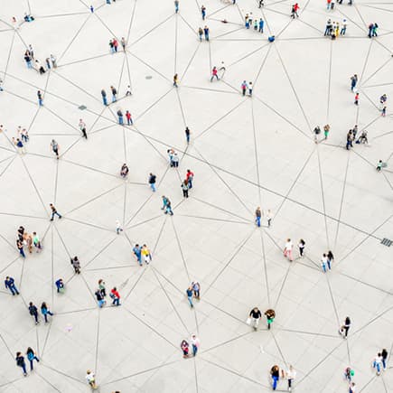 Overhead view of people gathered in various groups. Each group connected to another group by lines on the ground.
