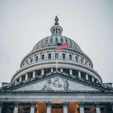 The U.S. Capitol dome with an US flag flying in front of it